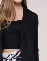 Blazer negro desestructurado de confección liviana y caída fluida, con cuello smoking, solapa corrida y mangas largas.