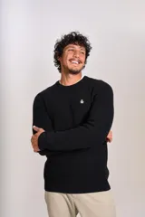 Sweater de punto grueso con cuello redondo, manga larga y puños acanalados. Presenta un pequeño logo bordado en el pecho.