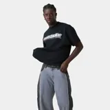 Camiseta negra de corte holgado con estampado frontal del logo "emestudios" en blanco con contorno negro y líneas horizontales en rojo, azul y blanco. Debajo del logo, la frase "ALWAYS GRATEFUL".