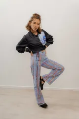 Pantalón de gabardina elastizada a rayas verticales en tonos azul, naranja y rojo, con cintura alta ajustable con cordón y corte recto.