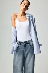 Top blanco de microfibra, corte entallado, con tirantes finos y escote redondo.