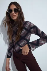 Body de mangas largas con cuello alto, confeccionado en tejido de tul semitransparente con estampado animal print en tonos grises y negros.