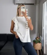 Blusa blanca de símil lino con cuello redondo fruncido, doble volado en las mangas con detalle de encaje.