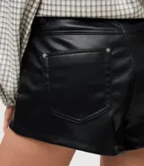 Short de tiro alto confeccionado en poliuretano con acabado que imita el cuero. Presenta un diseño estructurado con cierre frontal de cremallera visible y bolsillos laterales.