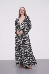 Vestido largo de poliéster con estampado floral en blanco y negro, escote en V, corte imperio con punto smock en la cintura y mangas largas con puños elásticos.
