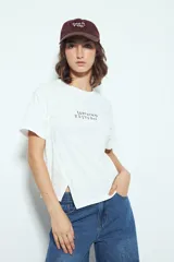 Remera blanca de manga corta con cuello redondo, aberturas laterales y bordado frontal con la frase "LIMITED EDITION" en negro.