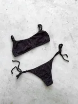 Conjunto de bikini color turquesa con tejido acanalado. El corpiño es tipo bandó con breteles finos regulables y espalda ajustable. La bombacha es vedetina con tiras ajustables a los costados.
