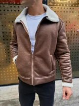 Campera tipo gamulán de cuero sintético color marrón, con forro interno y cuello de corderito sintético en color blanco. Presenta cierre frontal metálico y bolsillos laterales.