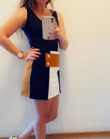 Minifalda blanca con aplique de cuero marrón con botones plateados.