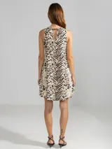 Vestido corto sin mangas, con corte en A, escote redondo y bajo redondeado con dobladillo asimétrico. Presenta un diseño estampado que combina motivos de animal print de leopardo y cebra.