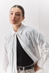 Camisa de algodón de calce relajado con cuello clásico, mangas largas con puños abotonados y cierre frontal con botones.