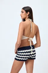 Short tejido color beige con diseño de ondas en punto calado.