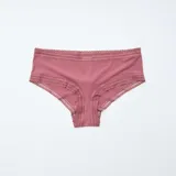 Pack de tres shortys Kiabi confeccionados en microfibra, con detalles de encaje en la cintura y el contorno de las piernas. Incluye un shorty verde con estampado floreado pequeño, uno liso de color rosado y uno en tono crudo con estampado de flores en tonos rojizos y verdes.