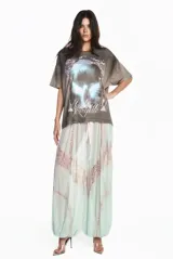 Remera gris de algodón con efecto lavado, corte oversize y estampa frontal gráfica con diseño de alas y texto.