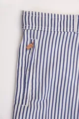Short de baño con rayas verticales azules y blancas, pretina elastizada con cordón ajustable, bolsillos laterales y traseros con cierre.