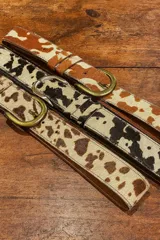 Cinto de cuero vacuno con pelo natural, con diseño de manchas tipo animal print. Cuenta con hebilla metálica y costuras reforzadas.