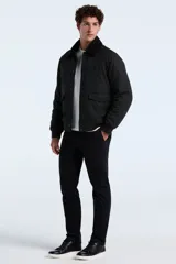 Campera tipo bomber color gris oscuro, con cuello de sherpa negro, cierre frontal con botones y bolsillos laterales con solapa. Presenta puños y ruedo de tejido elástico.