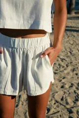 Short blanco de lino y rayón con cintura elástica y bolsillos laterales.