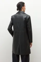 Blazer negro de eco cuero con solapas, cierre de botón frontal y pespuntes blancos en los bordes.