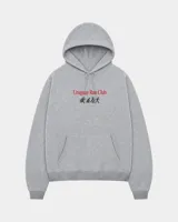 Canguro gris con capucha, cordones de ajuste y bolsillo tipo canguro al frente. Presenta un estampado en el pecho con la inscripción "Uruguay Run Club" en color rojo y una secuencia de siluetas corriendo debajo.