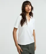 Blusa polo de manga corta en suedine de algodón, color blanco, con cuello abierto en V.