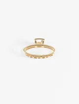 Broche para el cabello ovalado metálico color dorado con diseño geométrico.