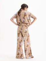 Pantalón East de tiro alto y botamanga amplia, confeccionado en morley liviano con estampado floreado. Presenta cintura estructurada con elástico y tablas en el lateral.