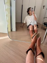 Bota texana blanca de cuero con bordados decorativos y taco de madera.