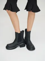 Botas estilo Chelsea de cuero vacuno rojo con grabado texturado tipo paisley, elásticos laterales negros y suela gruesa con taco de 5,5 cm.