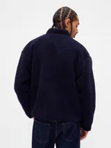 Canguro de polar negro con cierre frontal, cuello alto y bolsillo en el pecho con cierre y logo de la marca bordado.