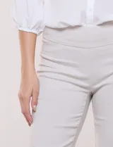 Pantalón color beige de corte entallado y largo cropped, confeccionado en tejido de punto con elasticidad técnica. Cuenta con pretina ancha y plana, bolsillos simulados al frente y bolsillos tipo ojal en la parte posterior.