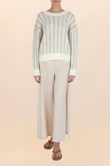 Suéter de punto con diseño de ochos verticales, cuello redondo, puños y ruedo acanalados. Presenta un acabado con sutiles destellos brillantes.
