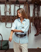 Camisa de corte amplio y tela suave con lino, color celeste. Presenta bordados frontales de un sol y un caballo. Cuenta con cuello clásico y cierre frontal de botones.