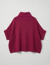 Capa tejida color fucsia, con cuello alto abotonado y mangas cortas estilo japonesa. Tejido de punto grueso.