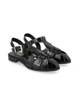 Sandalias planas de cuero color negro con efecto texturizado tipo reptil, diseño de tiras cruzadas y cierre de hebilla metálica dorada en el tobillo.