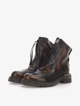 Bota corta de cuero bovino, color negro con efecto desgastado o metalizado grisáceo. Presenta cierre lateral con tirador y suela gruesa de goma con relieve.