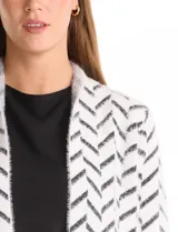 Cardigan de tejido soft con estampado de espiga en blanco y negro, corte recto, manga larga y bolsillos frontales amplios.