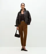 Pantalón skinny de mujer confeccionado en tejido sintético con efecto gamuza aterciopelado. Presenta un corte ajustado, recortes delanteros decorativos, cierre discreto y ruedo con dobladillo plegado.