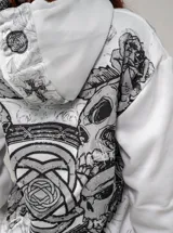 Campera de algodón y poliéster color blanco, con capucha, cierre frontal completo y bolsillos estilo canguro. Presenta un diseño estampado en serigrafía y DTG con motivos gráficos y calaveras en tonos grises y negros, y calce oversize.