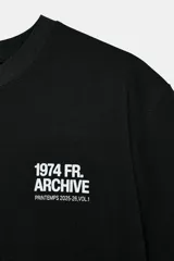 Camiseta negra de manga corta y cuello redondo, con estampado pequeño en blanco en el pecho que dice "1974 FR. ARCHIVE".