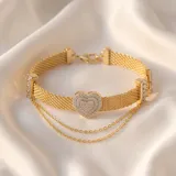 Pulsera de plata 925 con baño de oro, compuesta por una banda de malla metálica y una doble cadena fina colgante. Presenta un dije central en forma de corazón pavé con circonias.