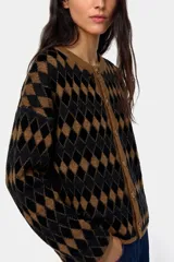 Saco tejido con diseño de rombos en color negro y marrón, con cuello redondo y cierre frontal de botones.