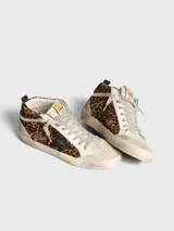 Zapatillas Golden Goose modelo Mid Star con diseño de caña media, confeccionadas en piel con estampado de leopardo y detalles en gamuza beige. Presentan una estrella lateral en color negro, cordones en tono neutro y suela con efecto desgastado.