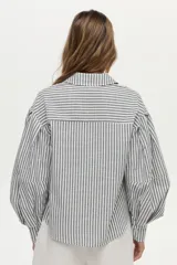 Camisa de algodón con rayas verticales grises y blancas, cuello camisero, mangas largas abullonadas y cierre frontal con botones.