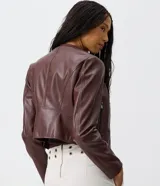 Campera basica de cuero sintetico color marron, con cuello redondo, cierre frontal completo y bolsillos laterales con cierre.
