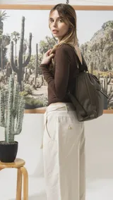Cartera convertible en mochila de diseño versátil, color tostado, con textura granulada. Cuenta con un bolsillo frontal con cierre, compartimento principal espacioso y correas ajustables para llevar al hombro o como mochila.