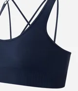 Top deportivo Get Over confeccionado en poliamida seamless, con escote redondo, breteles cruzados en la espalda y diseño sin costuras para mayor comodidad.