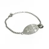 Pulsera de acero plateado con cadena de eslabones y dije ovalado grabado con la frase "Te quiero Mamá". Incluye un dije de corazón colgante.