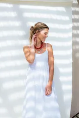 Vestido midi de broderie blanco, con breteles finos, escote redondo y corte holgado. Cuenta con forro interior de voile.