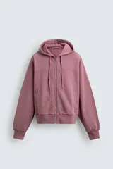 Sudadera tipo hoodie con cierre frontal de cremallera, diseño boxy fit, capucha ajustable con cordones, mangas largas con puños elásticos y bolsillos laterales. Presenta un acabado con efecto lavado.